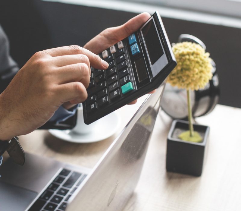 Worker Hand Using Calculator at Office